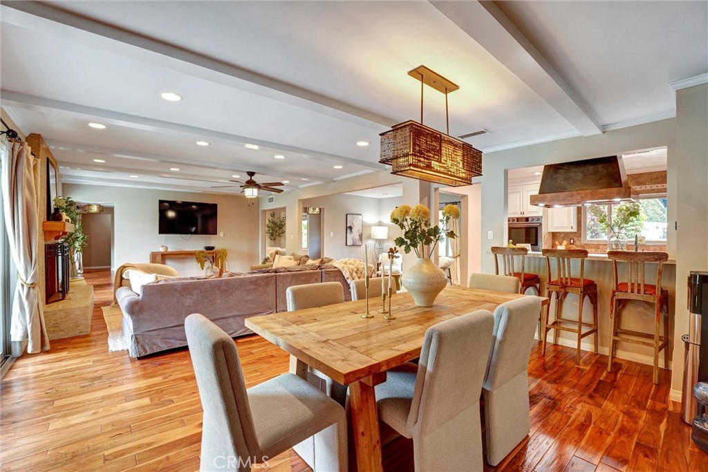 14955 Haynes Street Van Nuys, CA 91411 - Photo 12 of 35 a dining room with wooden floor a chandelier a wooden table and chairs