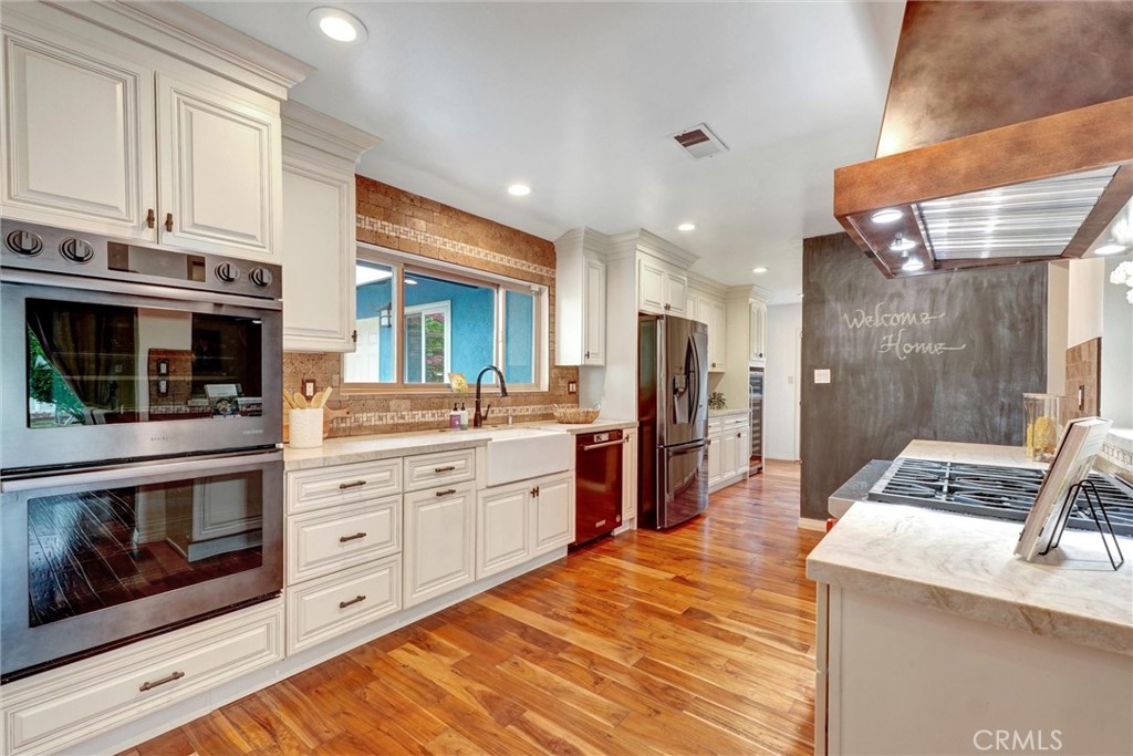 14955 Haynes Street Van Nuys, CA 91411 - Photo 13 of 35 a kitchen with stainless steel appliances kitchen island granite countertop a stove a sink and a refrigerator