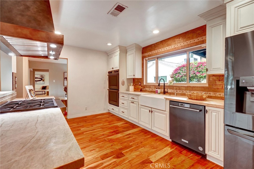 14955 Haynes Street Van Nuys, CA 91411 - Photo 14 of 35 a large kitchen with kitchen island granite countertop a large counter top space appliances and cabinets