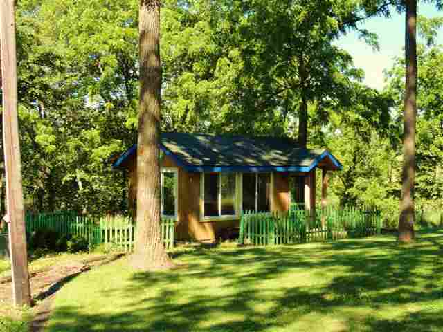 1373 South Snipe Hollow Road Elizabeth, IL 61028 - Photo 12 of 12 a view of a house with a big yard and potted plants and large trees
