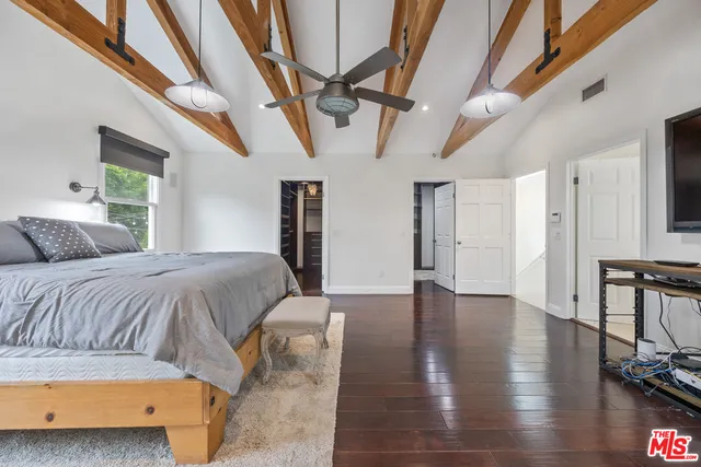 a spacious bedroom with a bed a table and chair