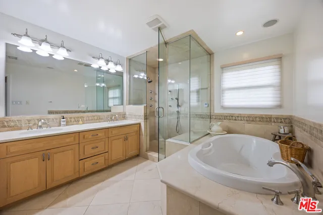 a bathroom with a sink double vanity granite tub and a mirror
