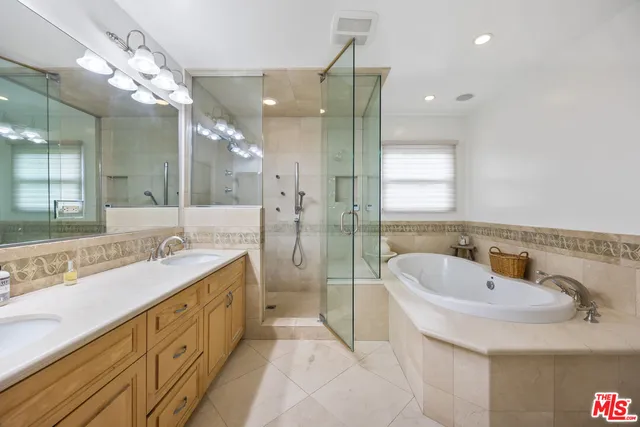 a bathroom with a double vanity sink mirror and shower