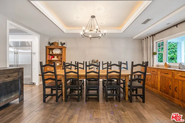 a dining room with furniture window entryway and wooden floor