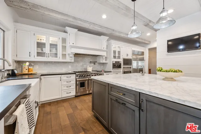 a large kitchen with stainless steel appliances granite countertop a stove and a sink