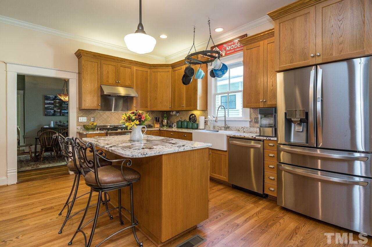 1218 Filmore Street Raleigh, NC 27605 - Photo 13 of 38 a kitchen with stainless steel appliances granite countertop a sink a stove and a refrigerator