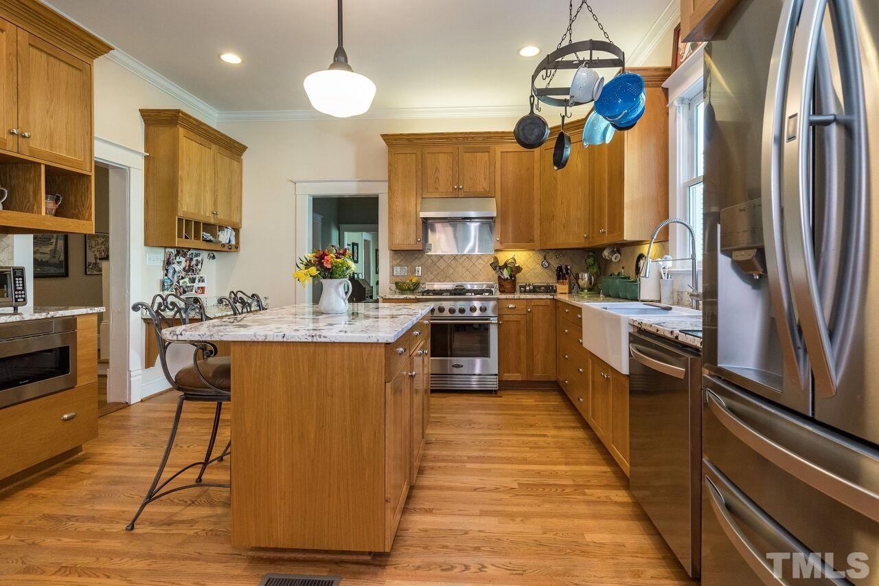 1218 Filmore Street Raleigh, NC 27605 - Photo 14 of 38 a kitchen with stainless steel appliances granite countertop a sink a stove top oven a counter space and cabinets