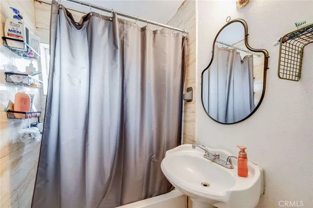 a bathroom with a sink a mirror and a shower curtain