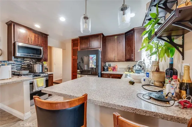 a kitchen with stainless steel appliances granite countertop a sink a stove and a wooden floors