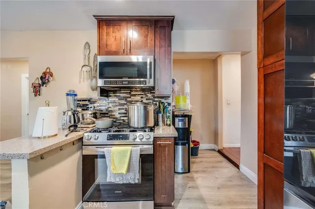 a kitchen with stainless steel appliances a stove a sink and a microwave