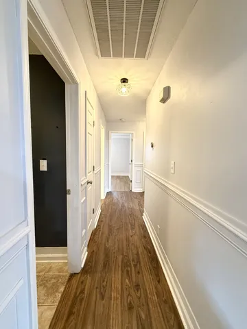 a view of a hallway with wooden floor