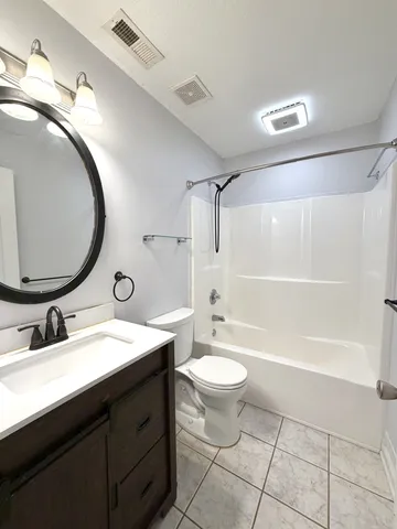 a bathroom with a double vanity sink a toilet a mirror and shower