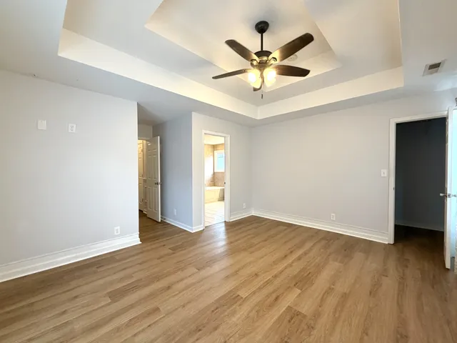 a view of a big room with wooden floor and windows