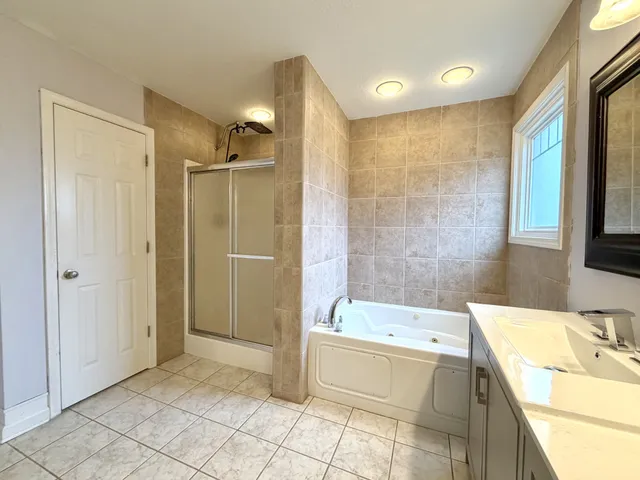 a bathroom with a tub sink and mirror