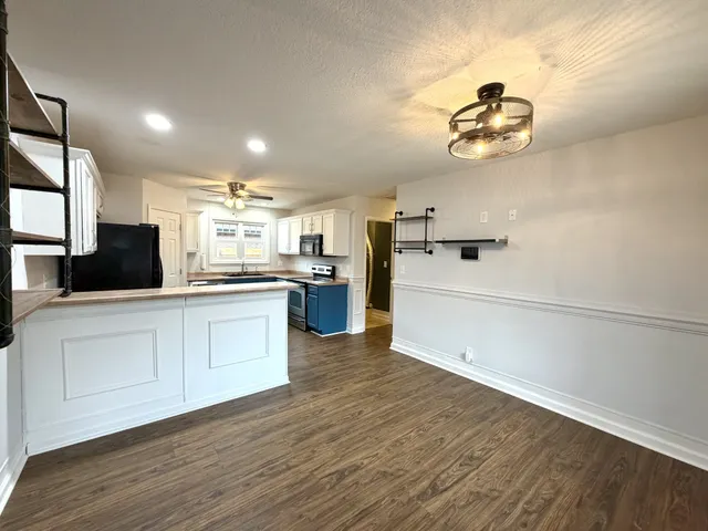 a kitchen with a wooden floor and white appliances