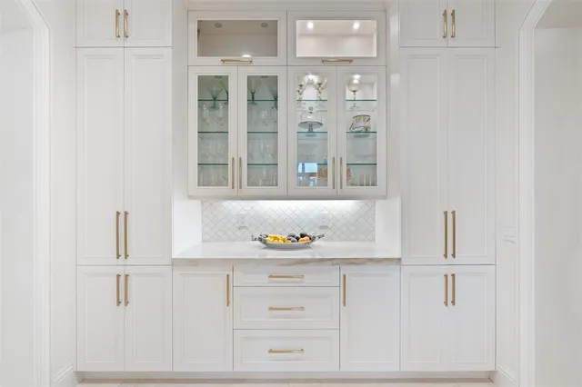 a view of a dining room with furniture a chandelier and large windows