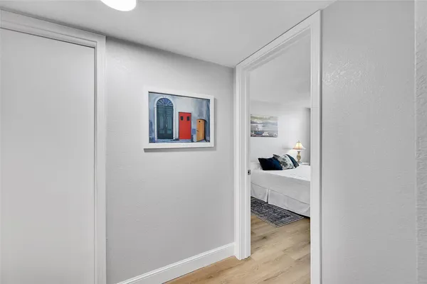 a bedroom with a large bed and wooden floor