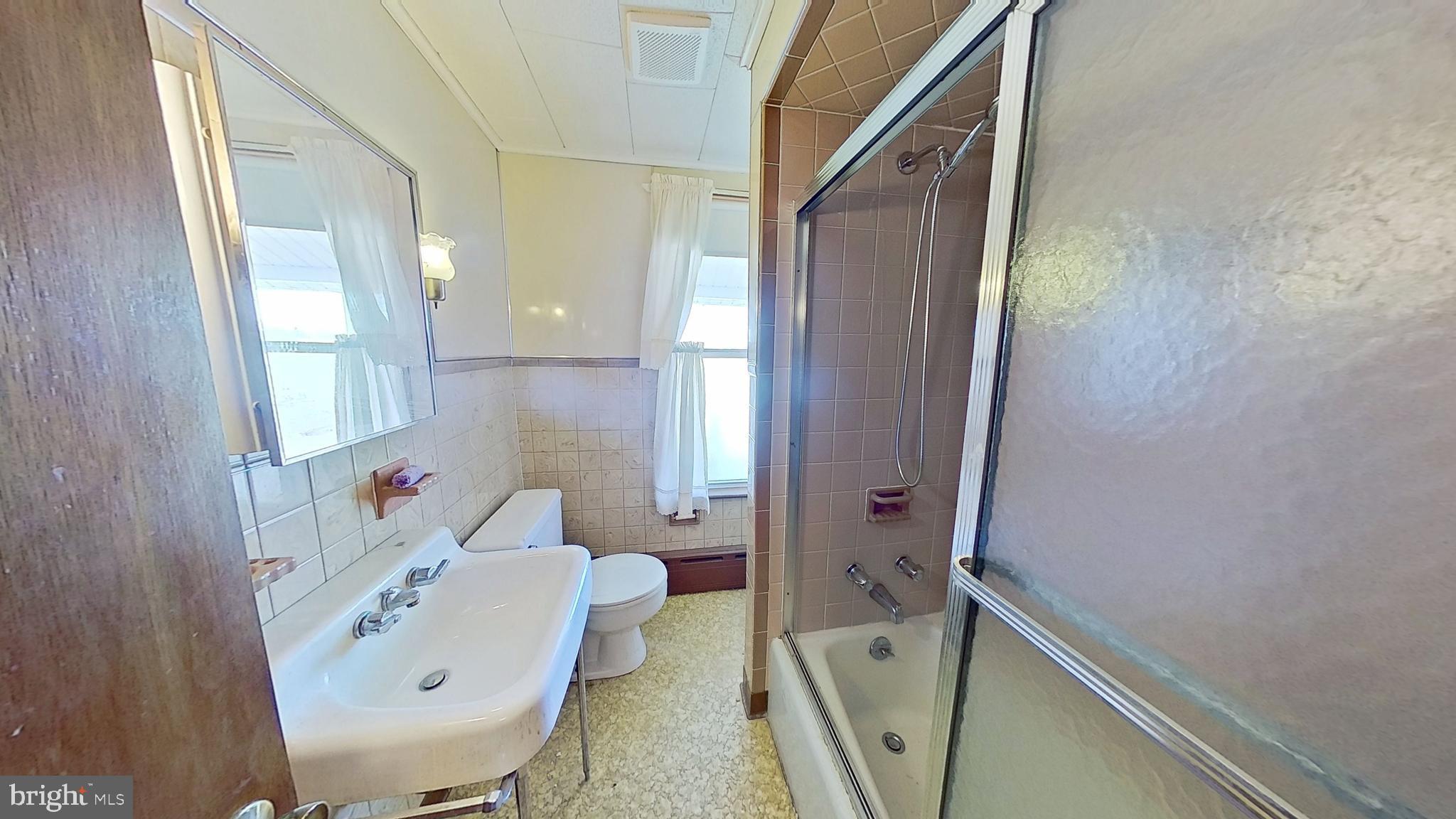1301 North Duke Street York, PA 17404 - Photo 6 of 8 a bathroom with a sink and mirror with toilet