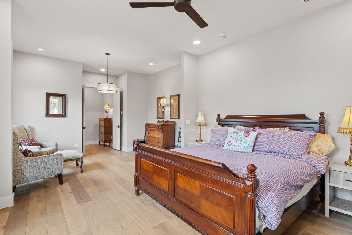 11400 Crumley Ranch Road Austin, TX 78738 - Photo 17 of 39 a spacious bedroom with a bed a couch and dresser