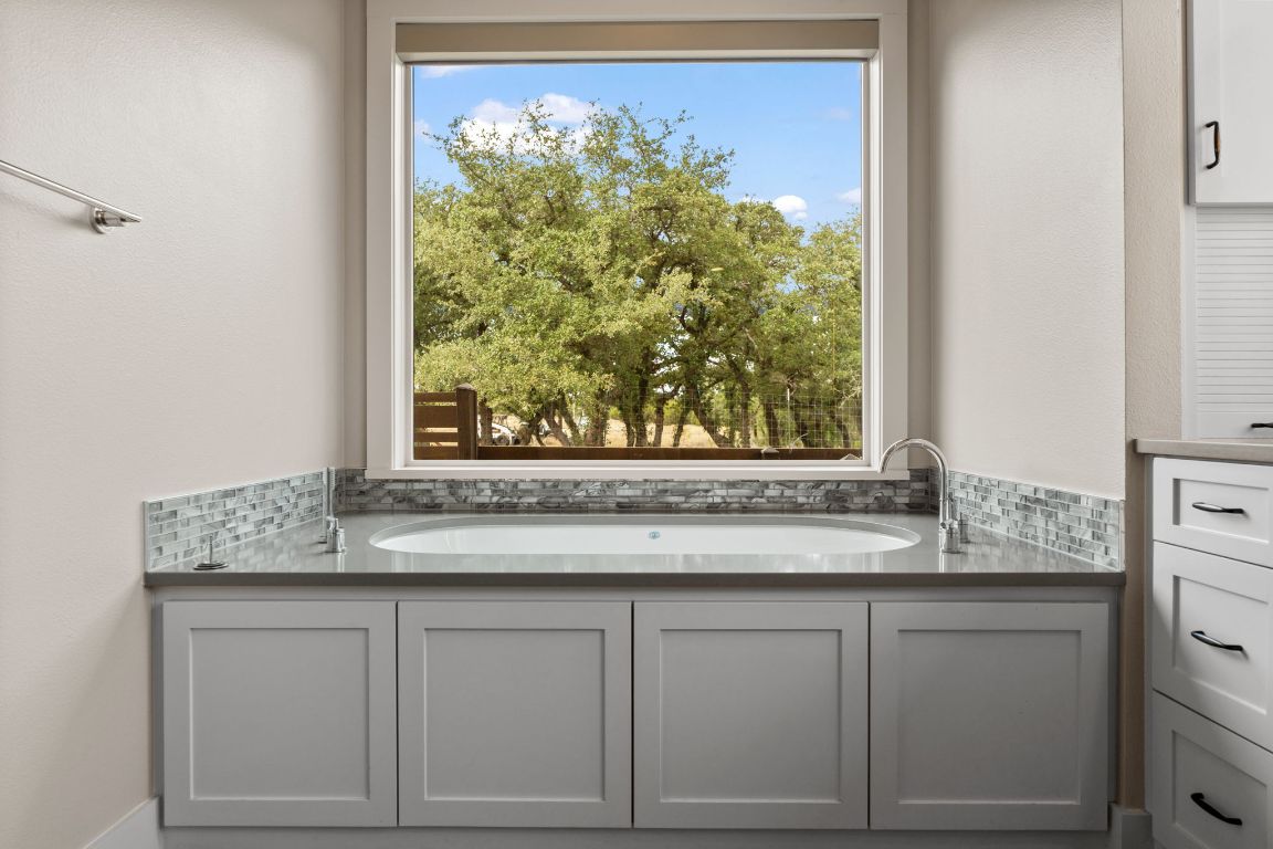 11400 Crumley Ranch Road Austin, TX 78738 - Photo 20 of 39 a sink with a granite countertop window and white cabinets