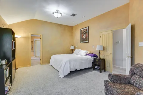 a bedroom with a bed dresser and a flat tv screen