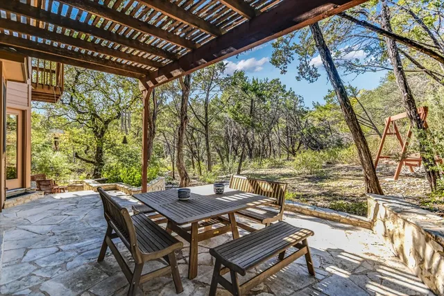 a view of a patio with table and chairs and couches with wooden floor and fence