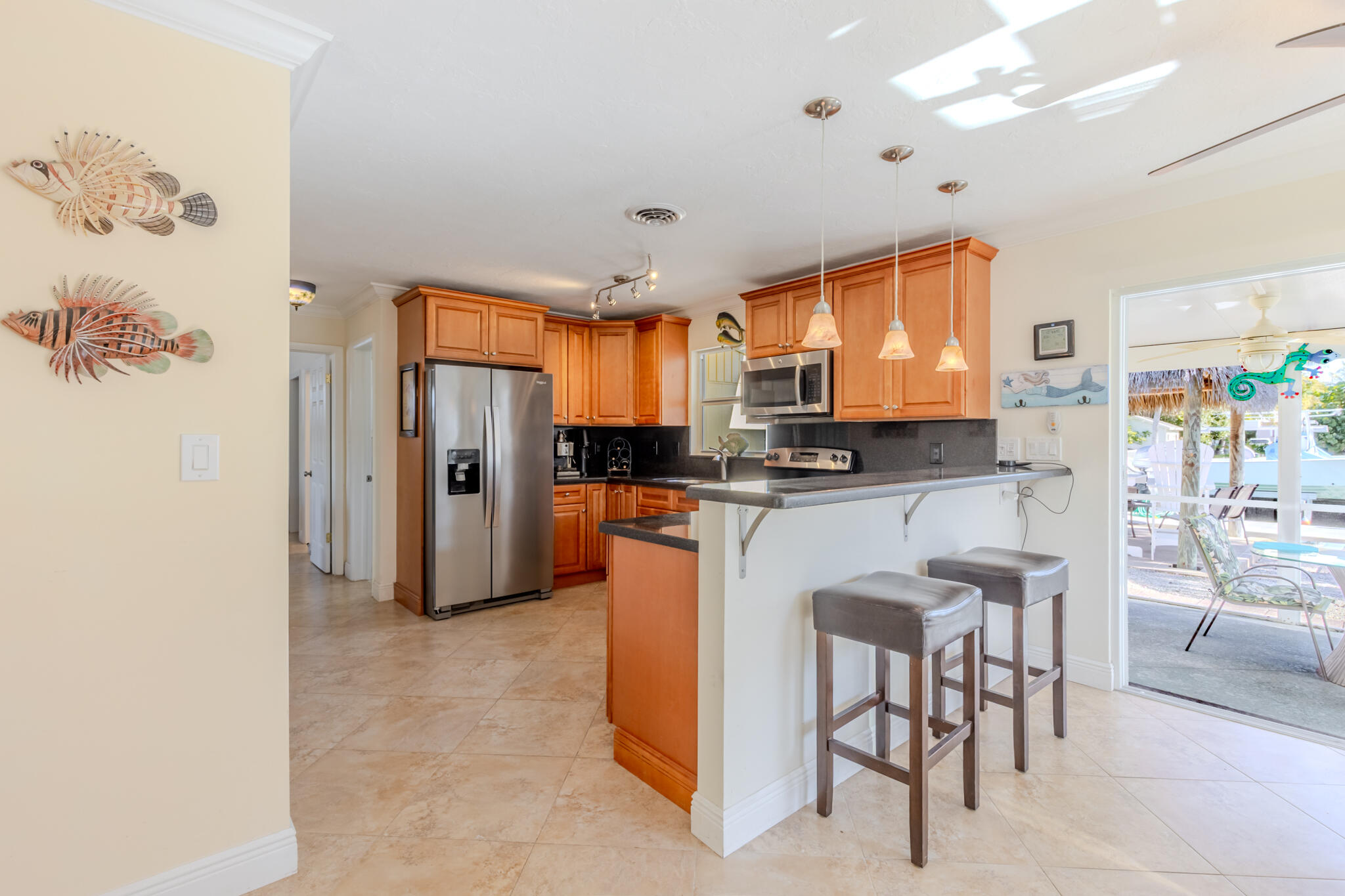 234 49th Street Marathon, FL 33050 - Photo 20 of 52 a kitchen with stainless steel appliances granite countertop a refrigerator a stove a sink a dining table and chairs with wooden floor