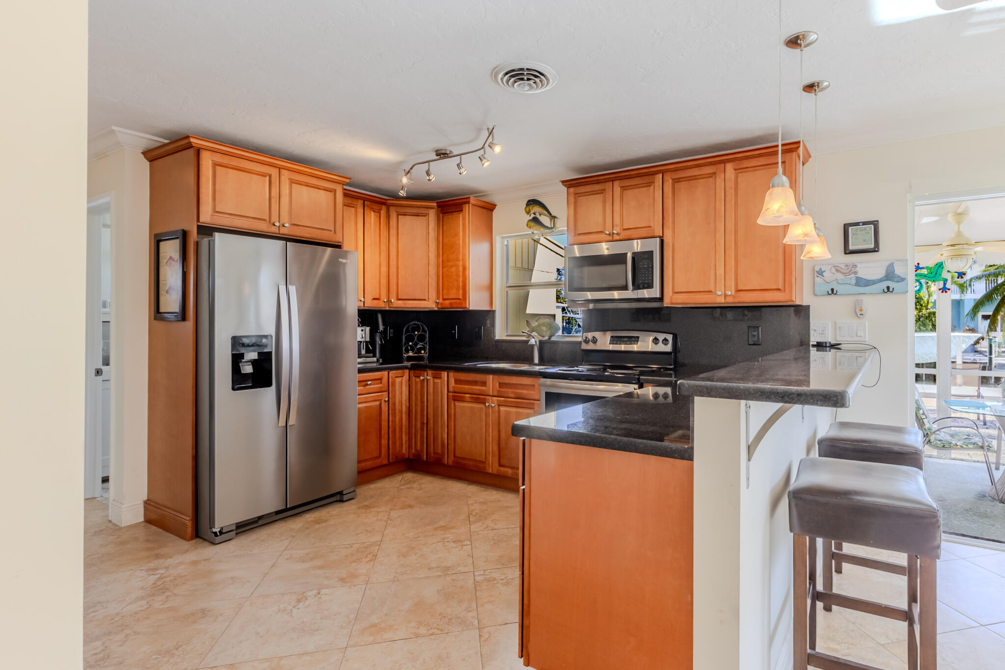 234 49th Street Marathon, FL 33050 - Photo 21 of 52 a kitchen with stainless steel appliances granite countertop a refrigerator a stove a sink and a microwave