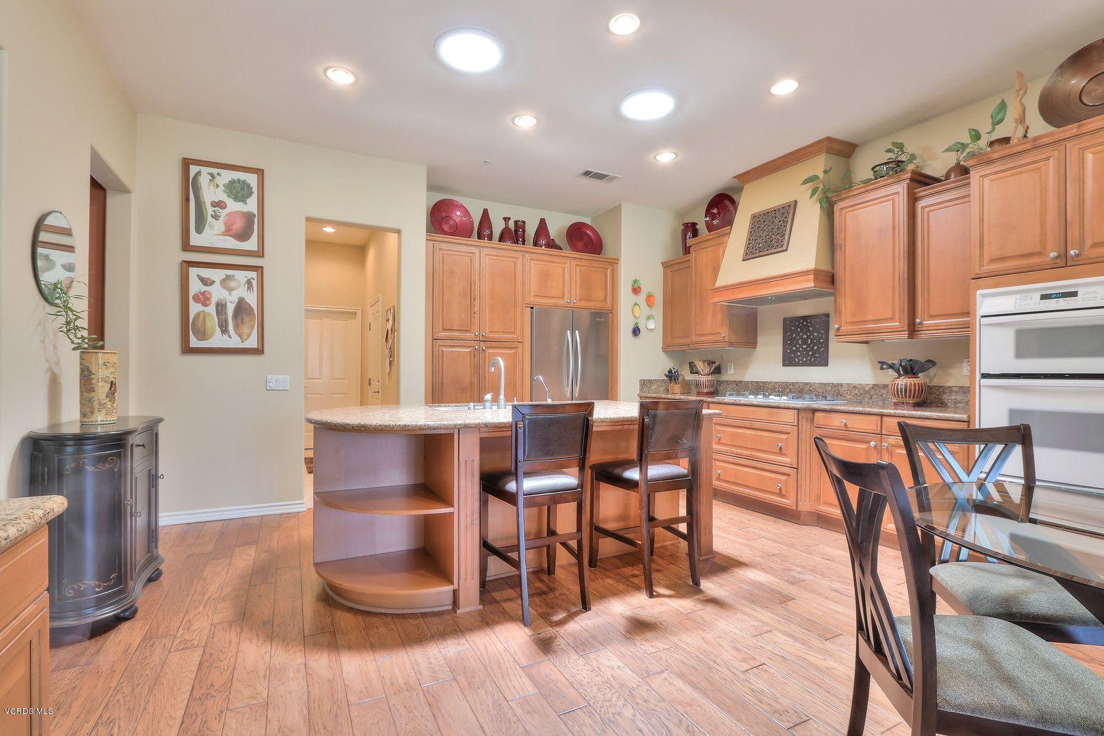 2011 Turnberry Drive Oxnard, CA 93036 - Photo 11 of 56 a dining room with stainless steel appliances granite countertop a table chairs and a refrigerator a sink with wooden floor