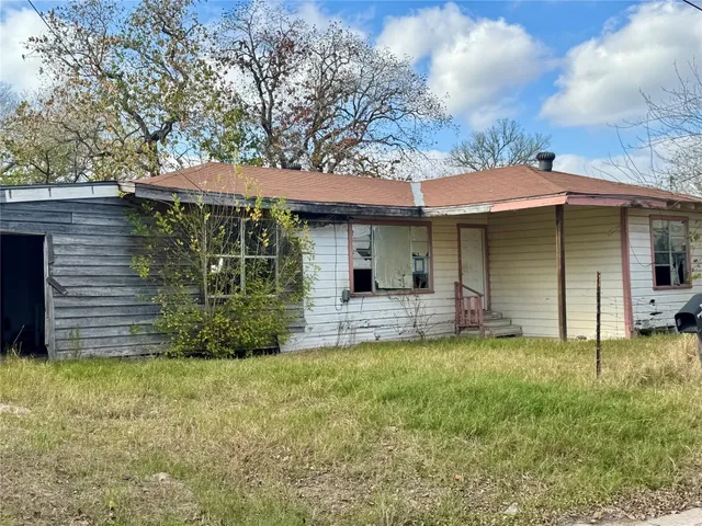 a view of a house with a yard and sitting area