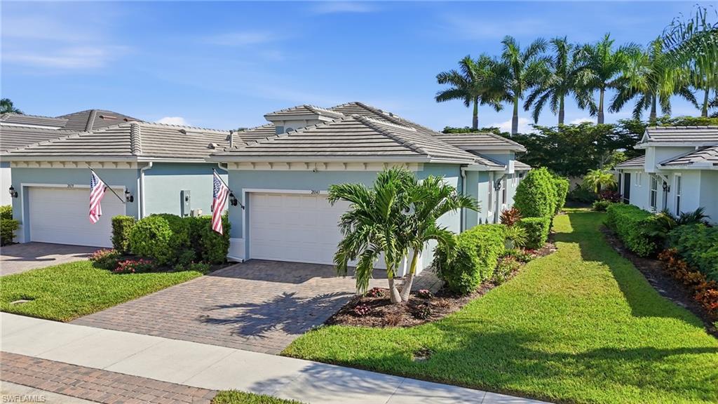 a front view of a house with a yard and palm trees