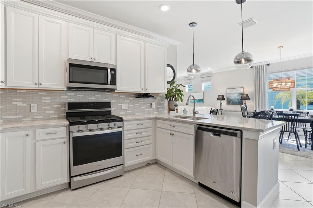 20143 Torch Key Way Estero, FL 33928 - Photo 6 of 26 a kitchen with white cabinets and appliances