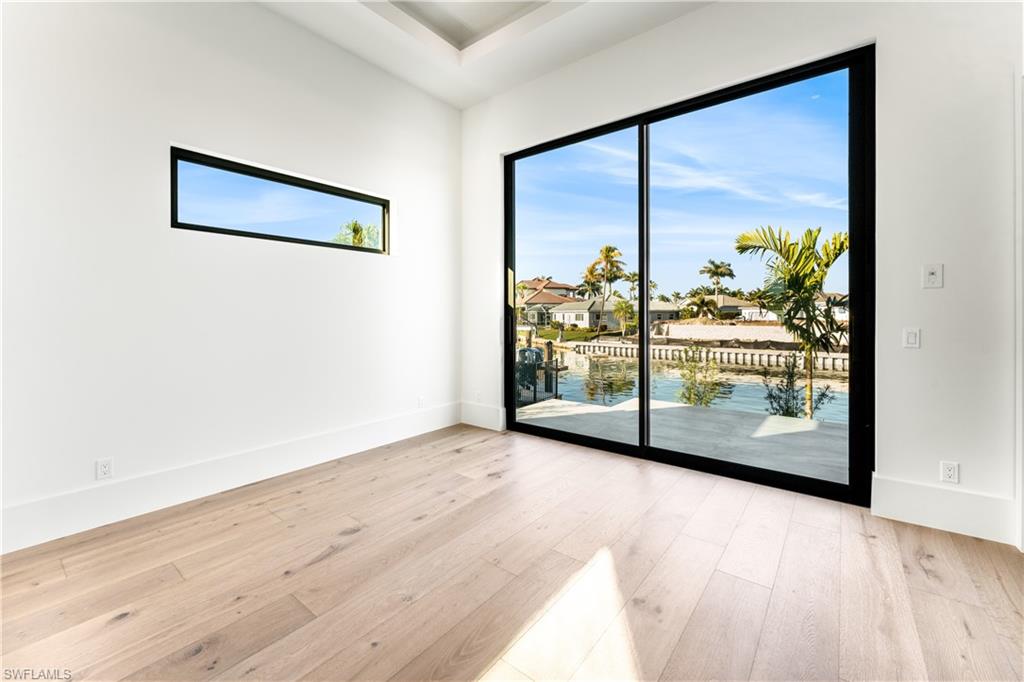 159 Dan River Court Marco Island, FL 34145 - Photo 29 of 38 Unfurnished room with light wood-style floors, a residential view, and a water view