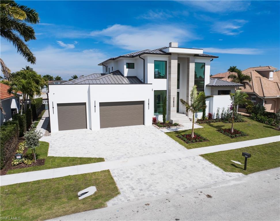 159 Dan River Court Marco Island, FL 34145 - Photo 3 of 38 Contemporary home featuring a standing seam roof, a garage, a front yard, decorative driveway, and stucco siding