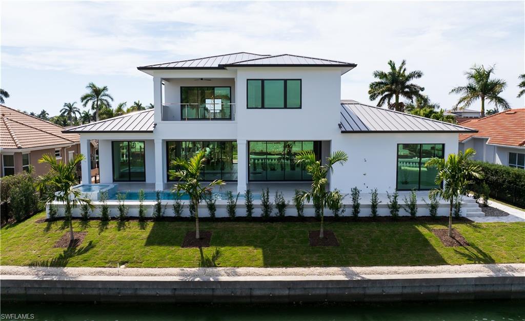 159 Dan River Court Marco Island, FL 34145 - Photo 4 of 38 Modern home with a standing seam roof, a garage, decorative driveway, and a front yard