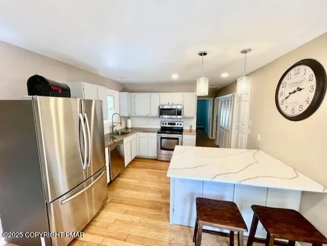 a kitchen with stainless steel appliances a refrigerator and a table
