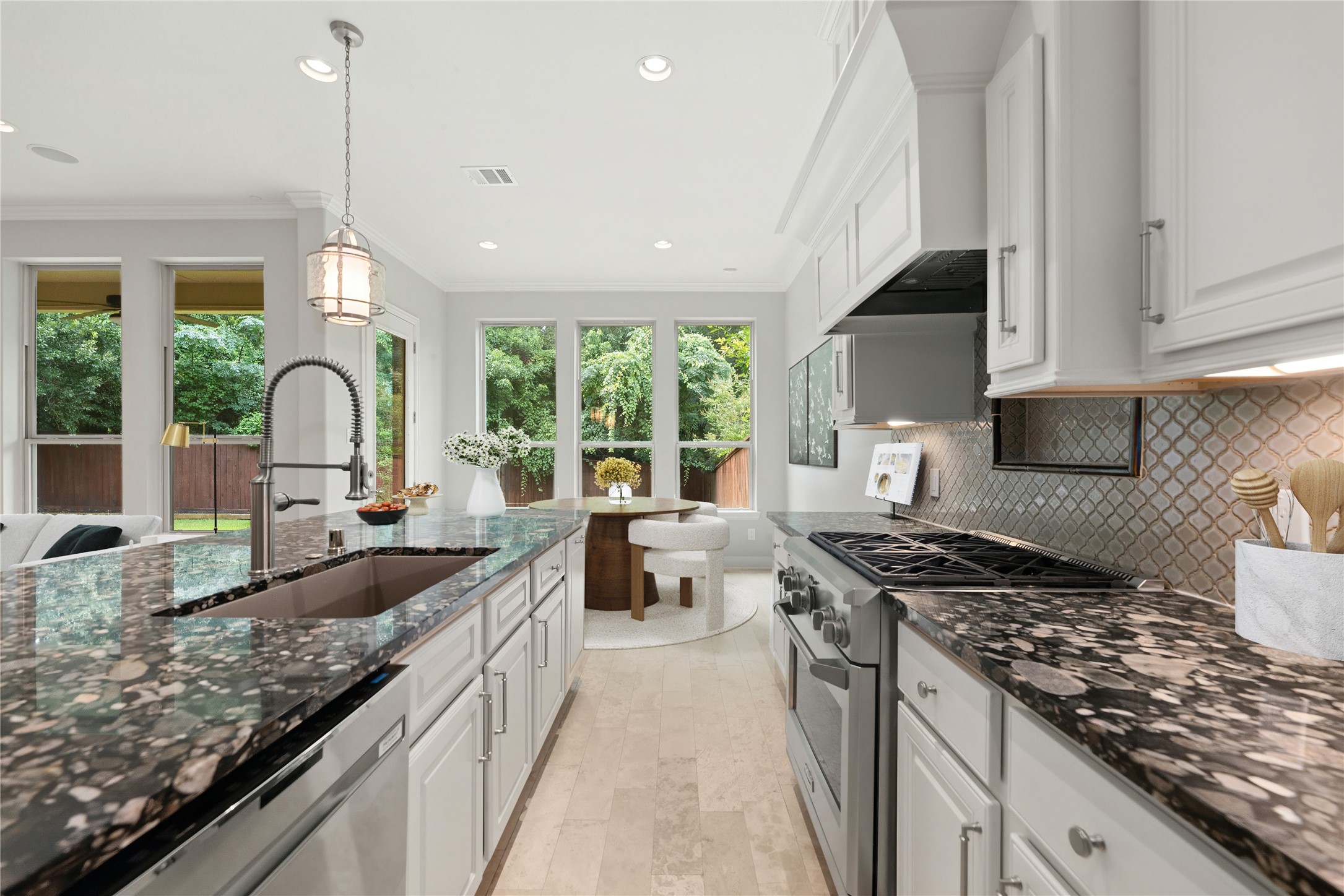 98 Herons Flight Place Spring, TX 77389 - Photo 9 of 29 Well-appointed kitchen with gas cooktop, dual sinks, decorative tile backsplash, and views to the breakfast nook and backyard. *Virtually Staged