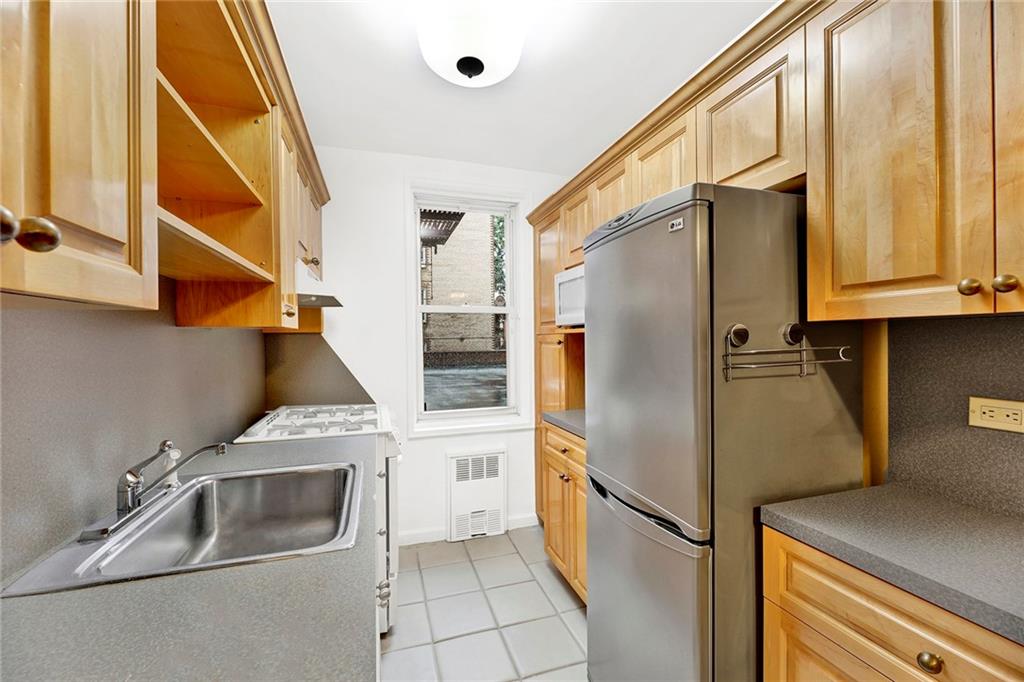 9411 Shore Road, Unit 1I Brooklyn, NY 11209 - Photo 11 of 13 a kitchen with stainless steel appliances a refrigerator and a sink