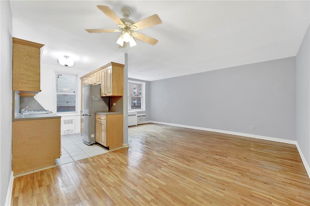 9411 Shore Road, Unit 1I Brooklyn, NY 11209 - Photo 2 of 13 a view of a kitchen with wooden floor and a ceiling fan
