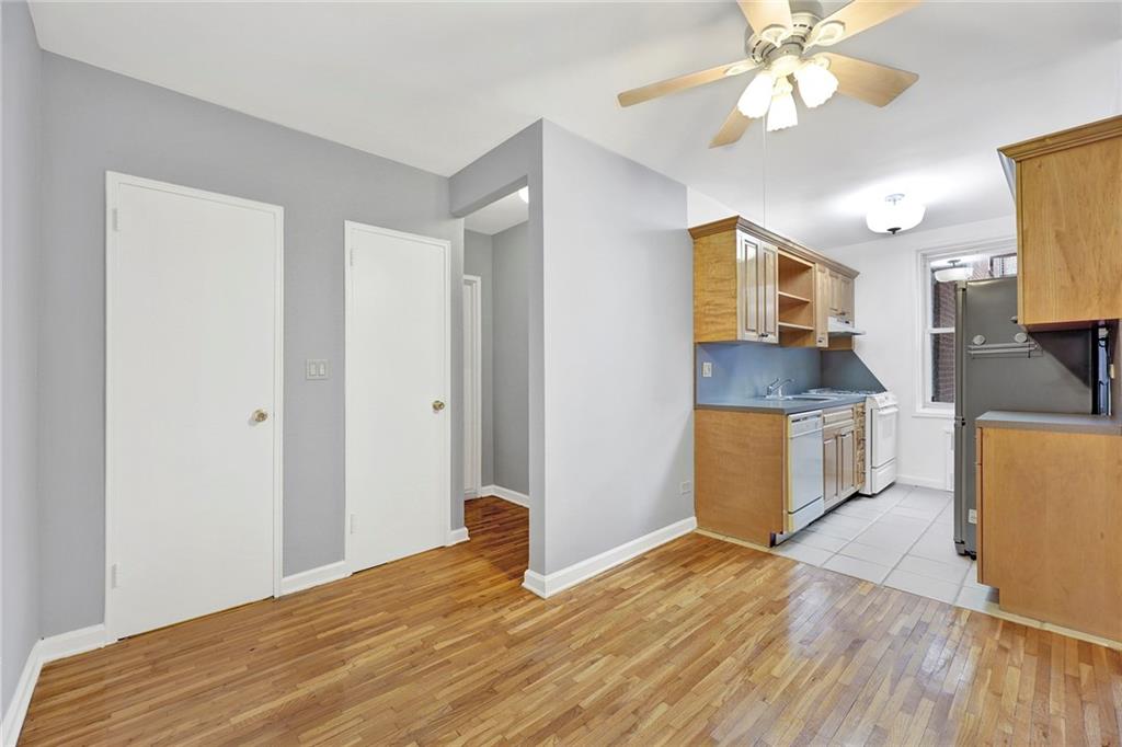 9411 Shore Road, Unit 1I Brooklyn, NY 11209 - Photo 4 of 13 a view of a kitchen with wooden floor and a ceiling fan