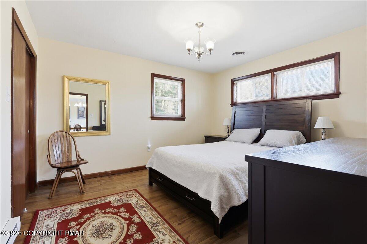 208 Shine Hill Road Henryville, PA 18332 - Photo 20 of 38 a bedroom with a bed and a chandelier
