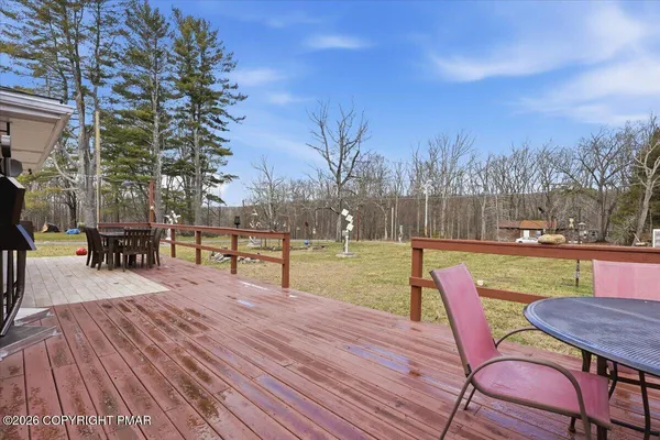 a view of a patio with table and chairs with wooden fence and floor