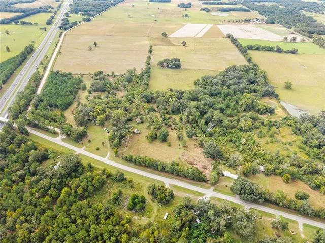 an aerial view of ocean and residential houses with outdoor space