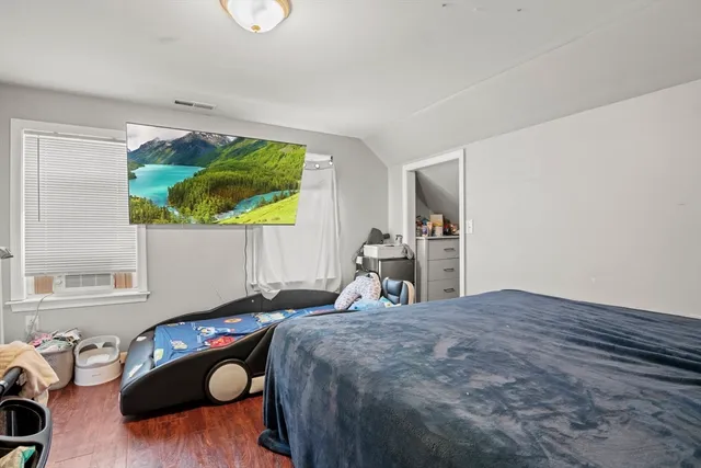 a bedroom with a bed and wooden floor