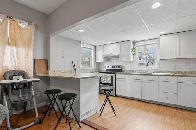 a kitchen with stainless steel appliances granite countertop a sink and a refrigerator