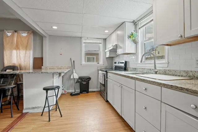 a kitchen with stainless steel appliances granite countertop a stove a sink and a microwave