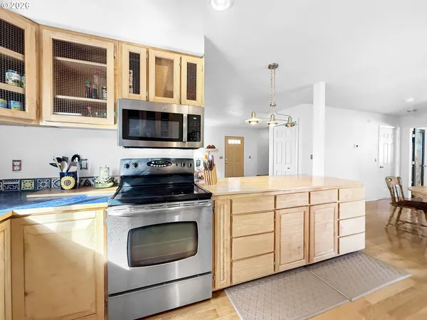 a kitchen with stainless steel appliances granite countertop a stove a sink and a microwave