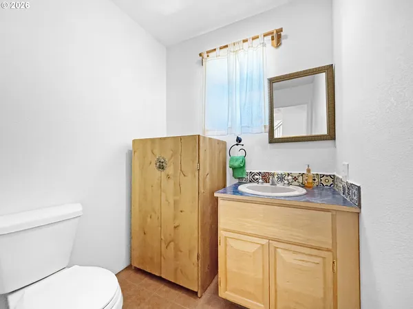 a bathroom with a granite countertop sink toilet and mirror