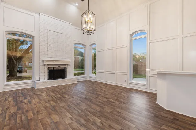 a view of a livingroom with wooden floor a fireplace and window