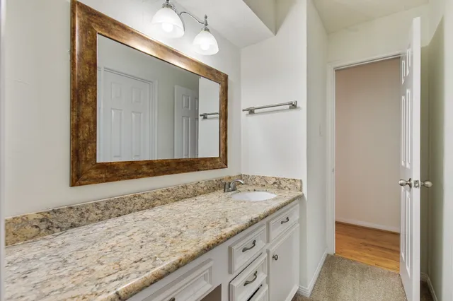 a bathroom with a granite countertop sink and a mirror